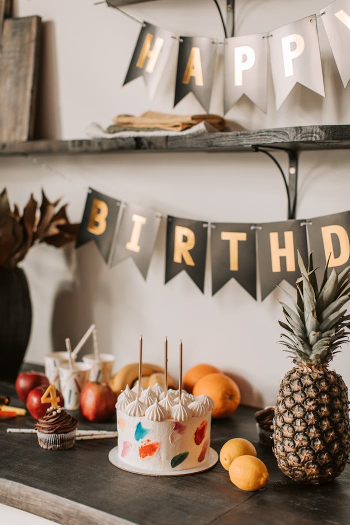 The Art of Drawing Readers In: Your attractive post title goes here A festive birthday setup with cake, fruits, and decoration banners indoors.